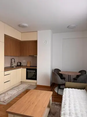 a living room with a table and a kitchen at BL Soul Apartment in Banja Luka