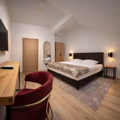 a bedroom with a bed and a desk and a chair at Motel Marić in Žepče