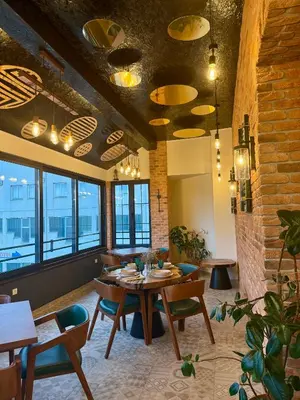 a dining room with a table and chairs and windows at Motel Marić in Žepče