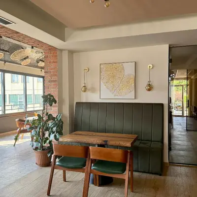 a dining room with a table and a green bench at Motel Marić in Žepče