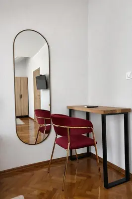 a mirror and a table and chairs in a room at Motel Marić in Žepče