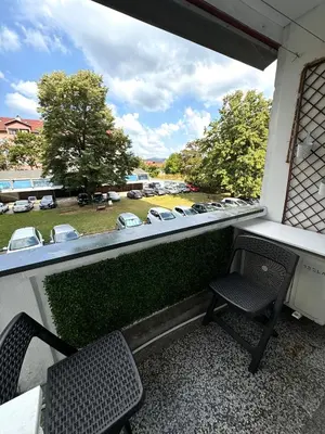 a balcony with two chairs and a view of a parking lot at Apartman Tanja in Banja Luka