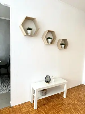 a room with a white table and three shelves on the wall at Apartman Tanja in Banja Luka