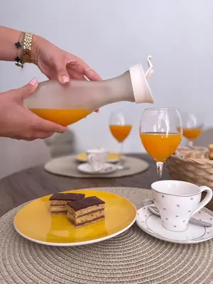 a person is pouring a glass of orange juice at Studio apartman Ana in Livno