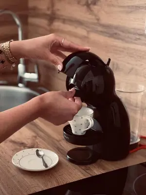 a woman is pouring coffee into a coffee maker at Studio apartman Ana in Livno