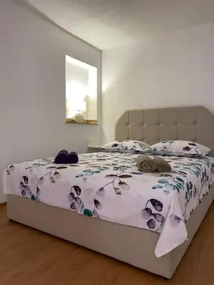 a bedroom with a large bed with a purple bedspread at Studio apartman Ana in Livno