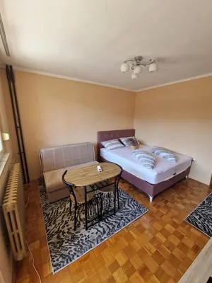 a bedroom with a bed and a table and a couch at Cozy in Zenica