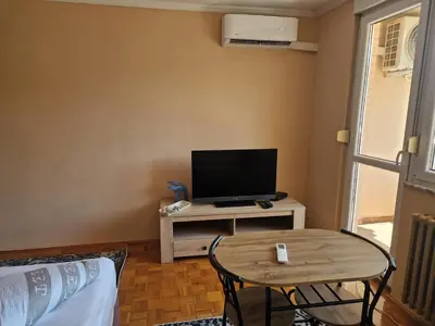 a living room with a tv and a table at Cozy in Zenica