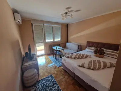 a bedroom with a bed and a couch and a table at Cozy in Zenica