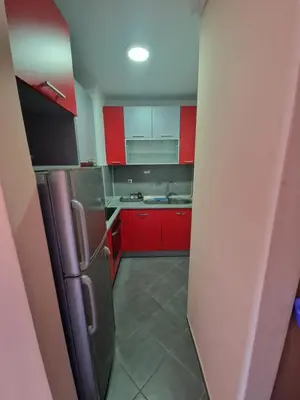 a kitchen with red cabinets and a stainless steel refrigerator at Cozy in Zenica