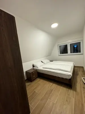 a small bedroom with a bed and two windows at Cupcake Apartments in Šišava