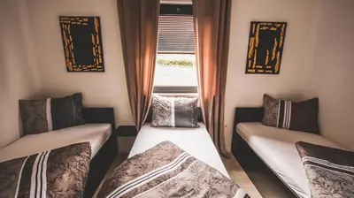a small room with two beds and a window at Villa Eden Bihać in Bihać