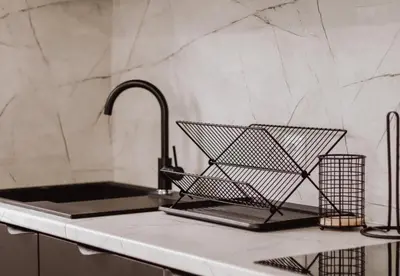 a kitchen sink with a metal basket on a counter at Villa Eden Bihać in Bihać