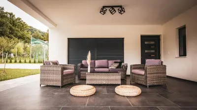 a patio with wicker chairs and a table at Villa Eden Bihać in Bihać