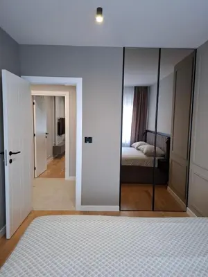 a bedroom with a glass door leading to a bed at Sparkle Home in Banja Luka