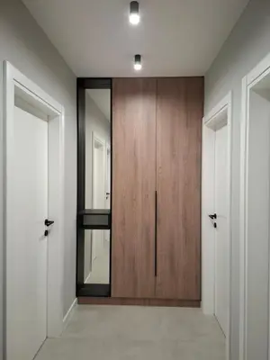 a hallway with a wooden door and a mirror at Sparkle Home in Banja Luka