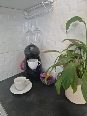 a coffee maker and two cups on a counter at Apartman Srbac in Srbac