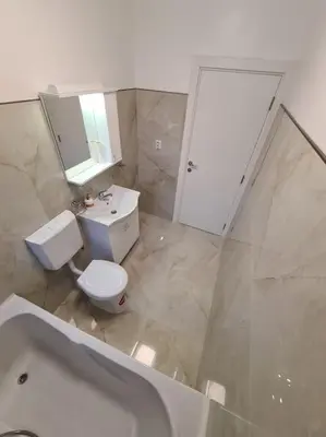 a bathroom with a toilet and a sink and a tub at Apartman Srbac in Srbac