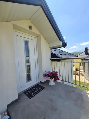 a porch with a white door and a vase of flowers at Dora in Livno