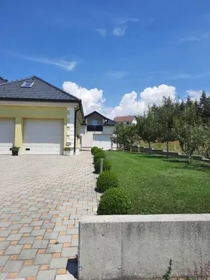 a house with a brick driveway in front of a yard at Dora in Livno
