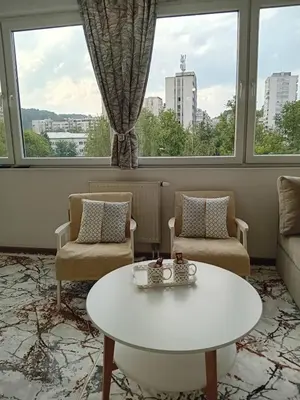 a living room with a white table and two chairs at AS Emporio Omega 2 in Tuzla