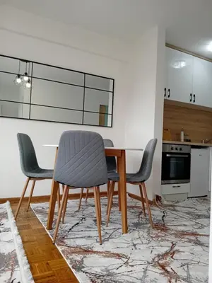 a dining room with a table and four chairs at AS Emporio Omega 2 in Tuzla
