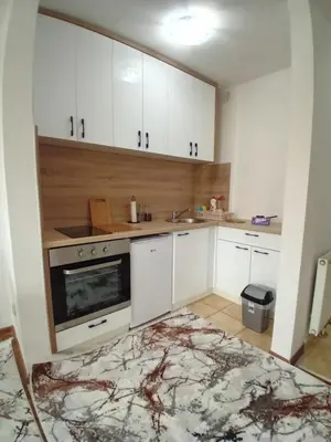 a kitchen with white cabinets and a sink at AS Emporio Omega 2 in Tuzla