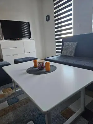 a white coffee table in a living room with a couch at Apartman D&A in Šišava