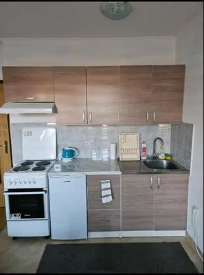 a kitchen with a white stove and wooden cabinets at Apartman D&A in Šišava
