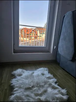 a white furry rug on the floor in front of a door at Apartman D&A in Šišava