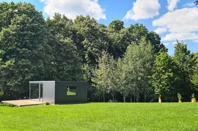 a small shed in the middle of a grassy field at Kućica za odmor Srbac in Srbac