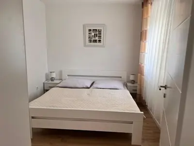 a white bedroom with a white bed in a room at Apartman Aldijana in Ripač