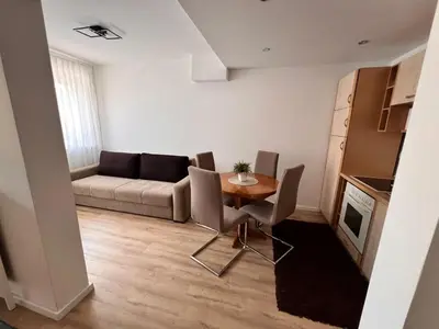 a living room with a couch and a table and chairs at Apartman Aldijana in Ripač
