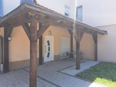 a wooden pergola in front of a building at Apartman Aldijana in Ripač