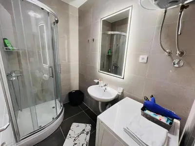 a small bathroom with a shower and a sink at Apartman Tara Lux in Banja Luka