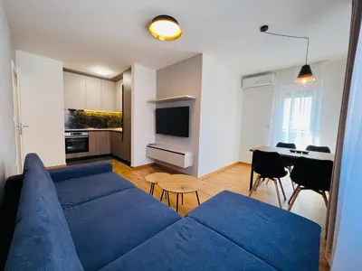 a living room with a blue couch and a table at Apartman Tara Lux in Banja Luka