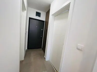 a hallway with a black door and white walls at Apartman Tara Lux in Banja Luka