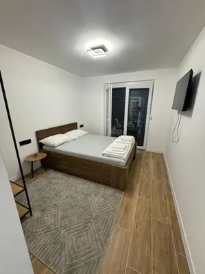 a white room with a bed and a television at Villa Sofia in Bihać
