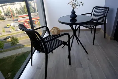 a table and chairs in a room with a window at Apartman Boutique Banja Luka in Banja Luka