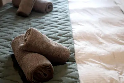 a pile of towels laying on a bed at Apartman Boutique Banja Luka in Banja Luka