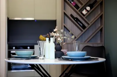 a white table with blue plates and wine bottles on it at Apartman Boutique Banja Luka in Banja Luka