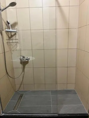 a bathroom with a shower with a glass door at City Apartment Lukavac in Lukavac