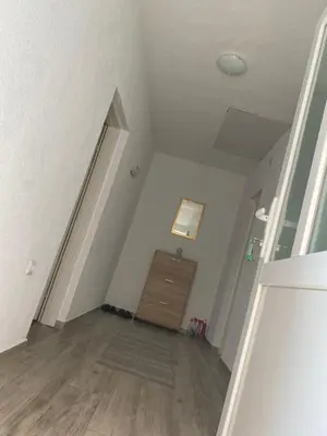 an attic room with a door and a wooden floor at Apartman Pavić in Livno