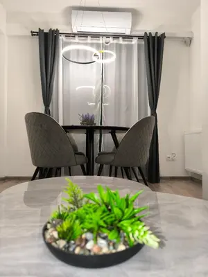 a dining room table with two chairs and a bowl of plants at Apartman Dioniz Fojnica in Fojnica
