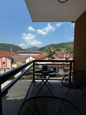 a balcony with a table and chairs on a balcony at Apartman Dioniz Fojnica in Fojnica