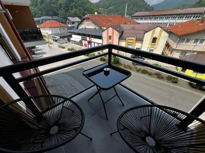 a balcony with two chairs and a table on it at Apartman Dioniz Fojnica in Fojnica