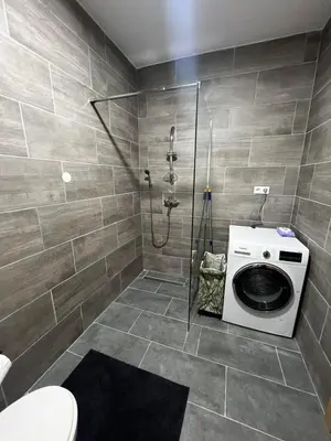 a bathroom with a shower and a washing machine at Apartman Zen Fojnica in Fojnica