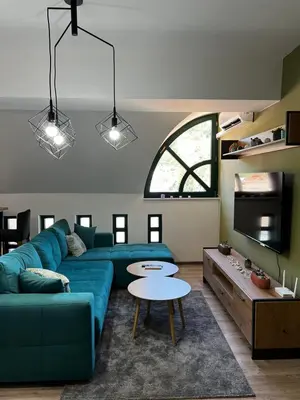 a living room with a blue couch and a table at Apartman Zen Fojnica in Fojnica