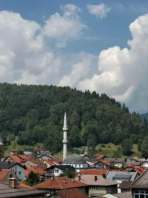 a view of a town with a tower and a mountain at Apartman Zen Fojnica in Fojnica