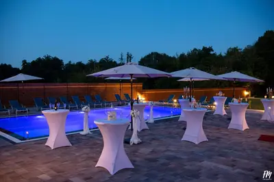 a group of tables and umbrellas next to a pool at Villa Djuric in Slatina Varoš